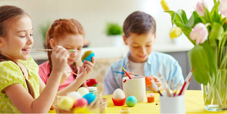 bambini che dipingono delle uova di Pasqua