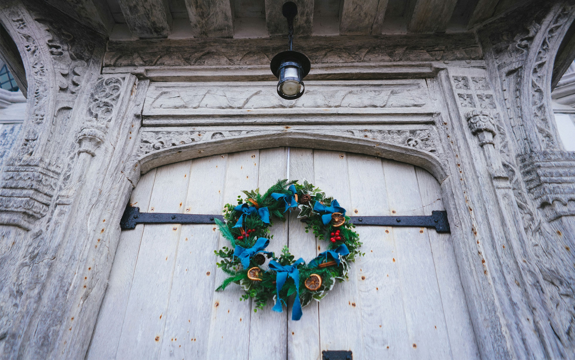 couronne de noel sur une porte d'église en bois blanc