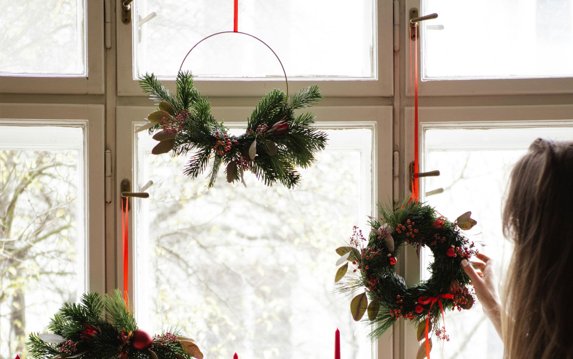 couronnes de noël en sapin suspendues à une fenêtre