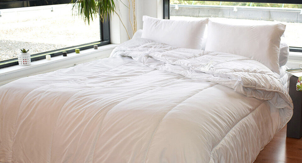 piumino e cuscino letto bianco