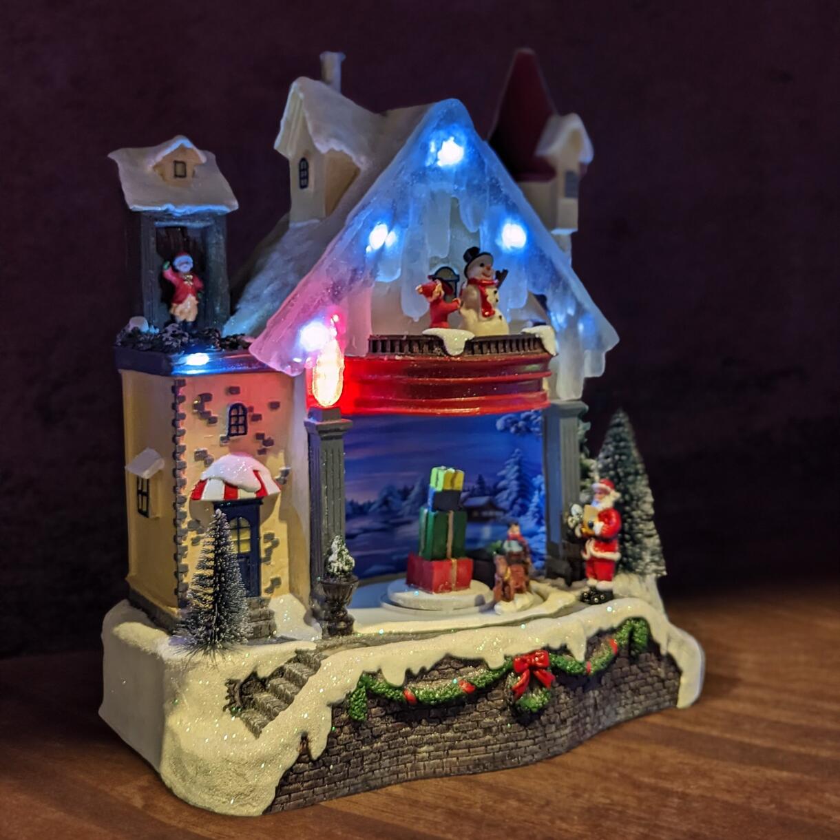Maison du bonhomme de neige enneigée et illuminée à piles 1